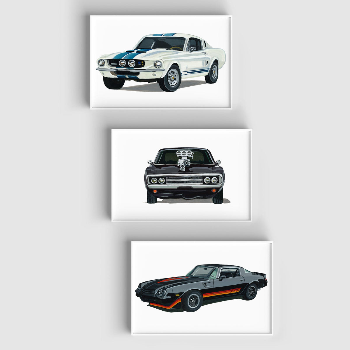 Ford Mustang GT500, Chevrolet Camaro Z28 and Dodge Charger R/T art prints staggered vertically on a pale wall