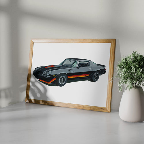 Black Chevrolet Camaro Z28 art print in a wooden frame beside a potted plant