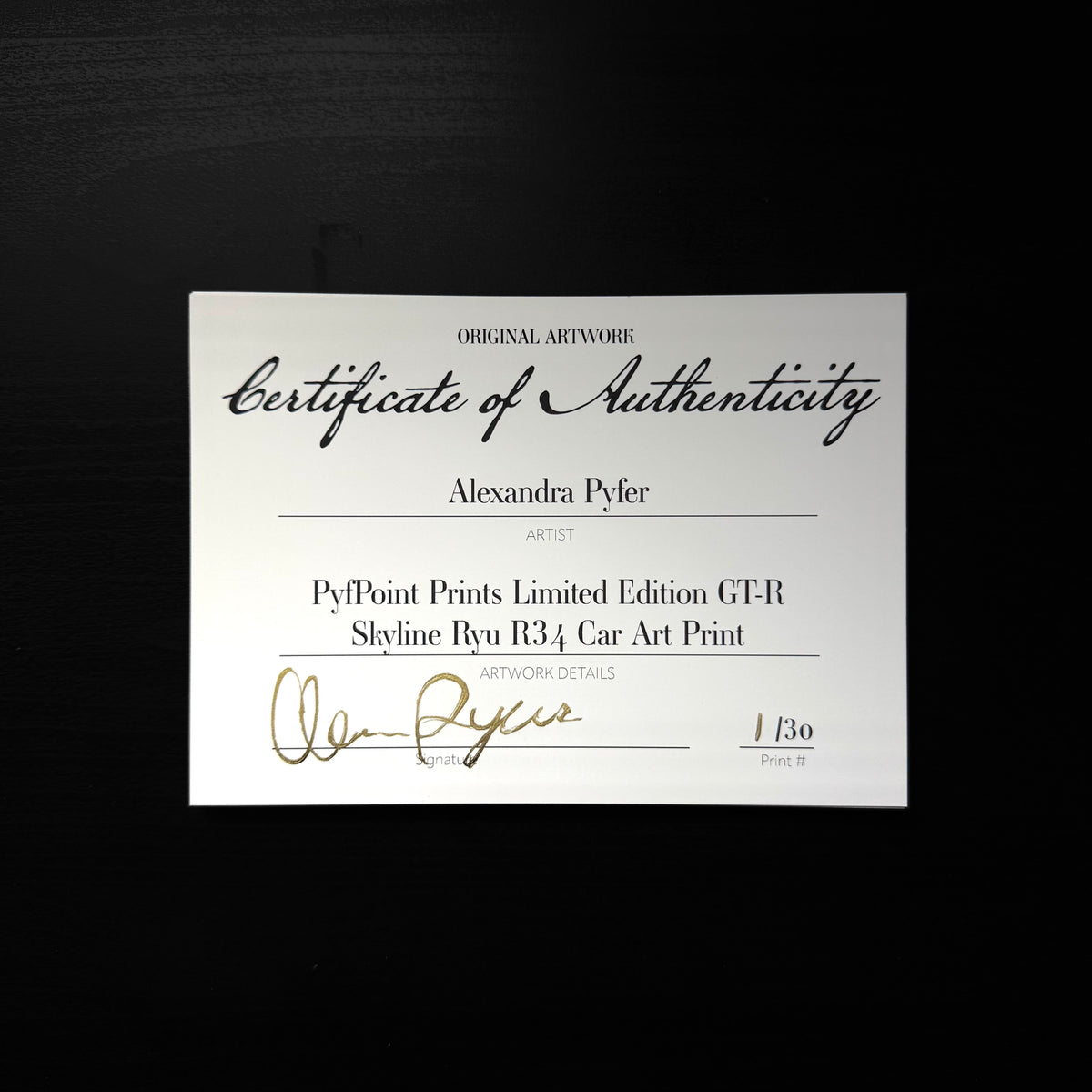 Certificates of Authenticity for the limited edition Nissan Skyline GT-R R34 art print fanned out on a dark table, each hand-signed in gold and numbered, the front one reading 01 of 30