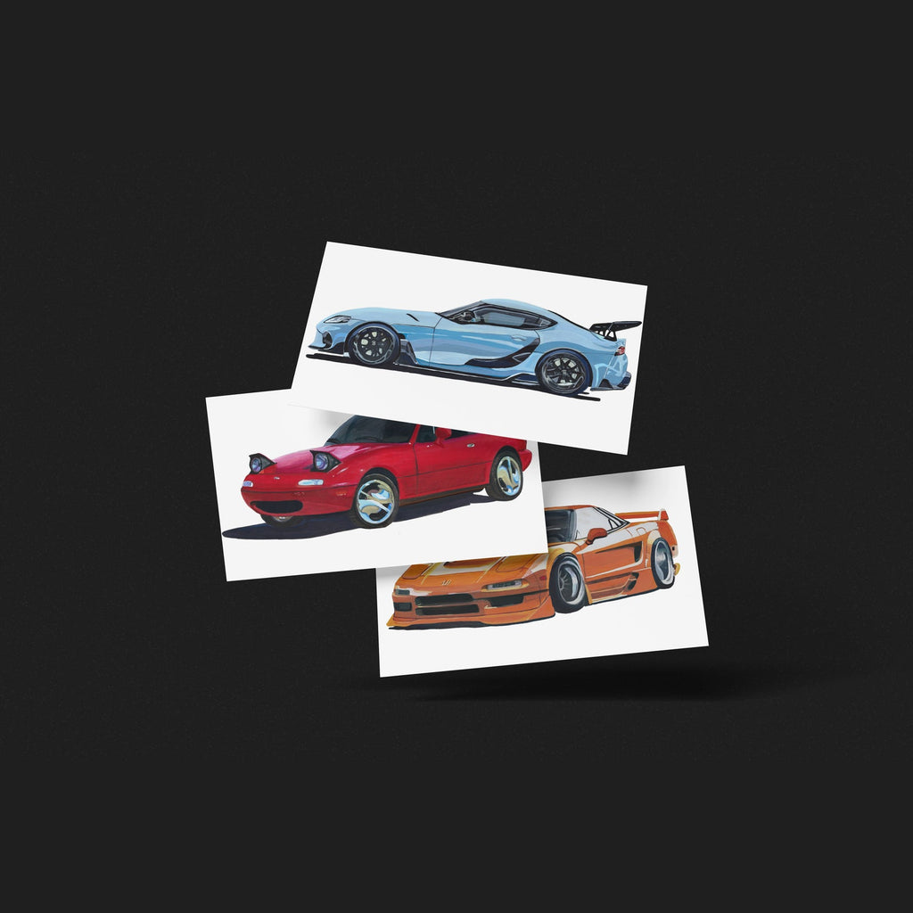 Three car art prints in light blue, red and orange fanned out on a black background