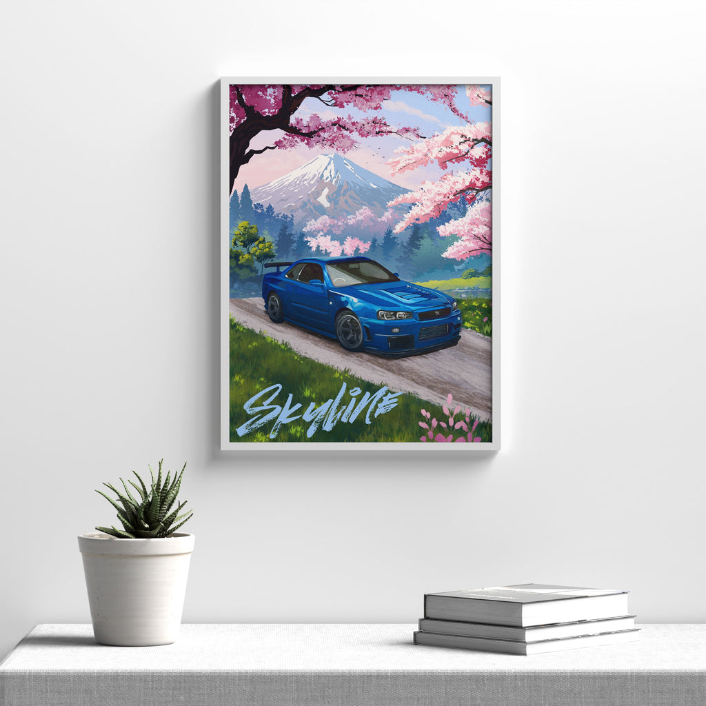 Blue Nissan Skyline GT-R R34 art print in a white frame hanging above a console table with a small plant and books