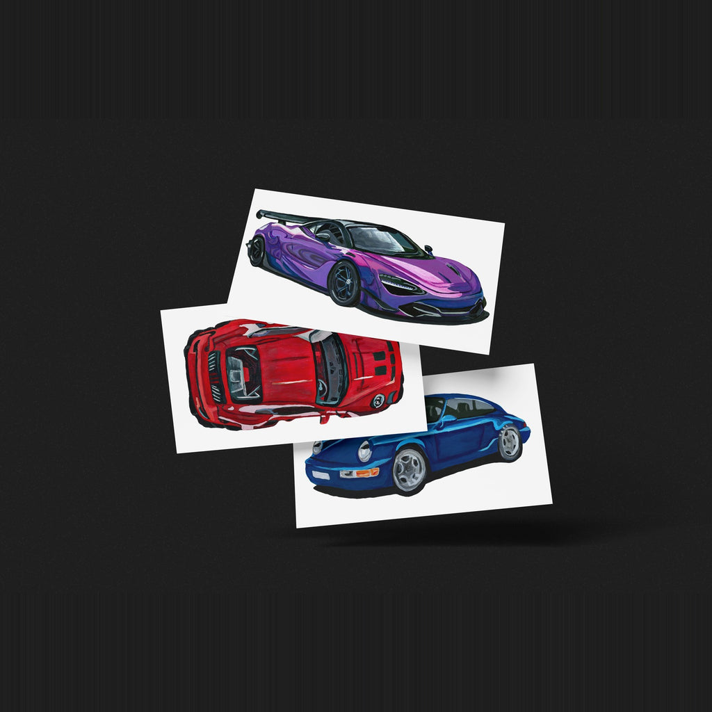 Three car art prints fanned out on a dark background