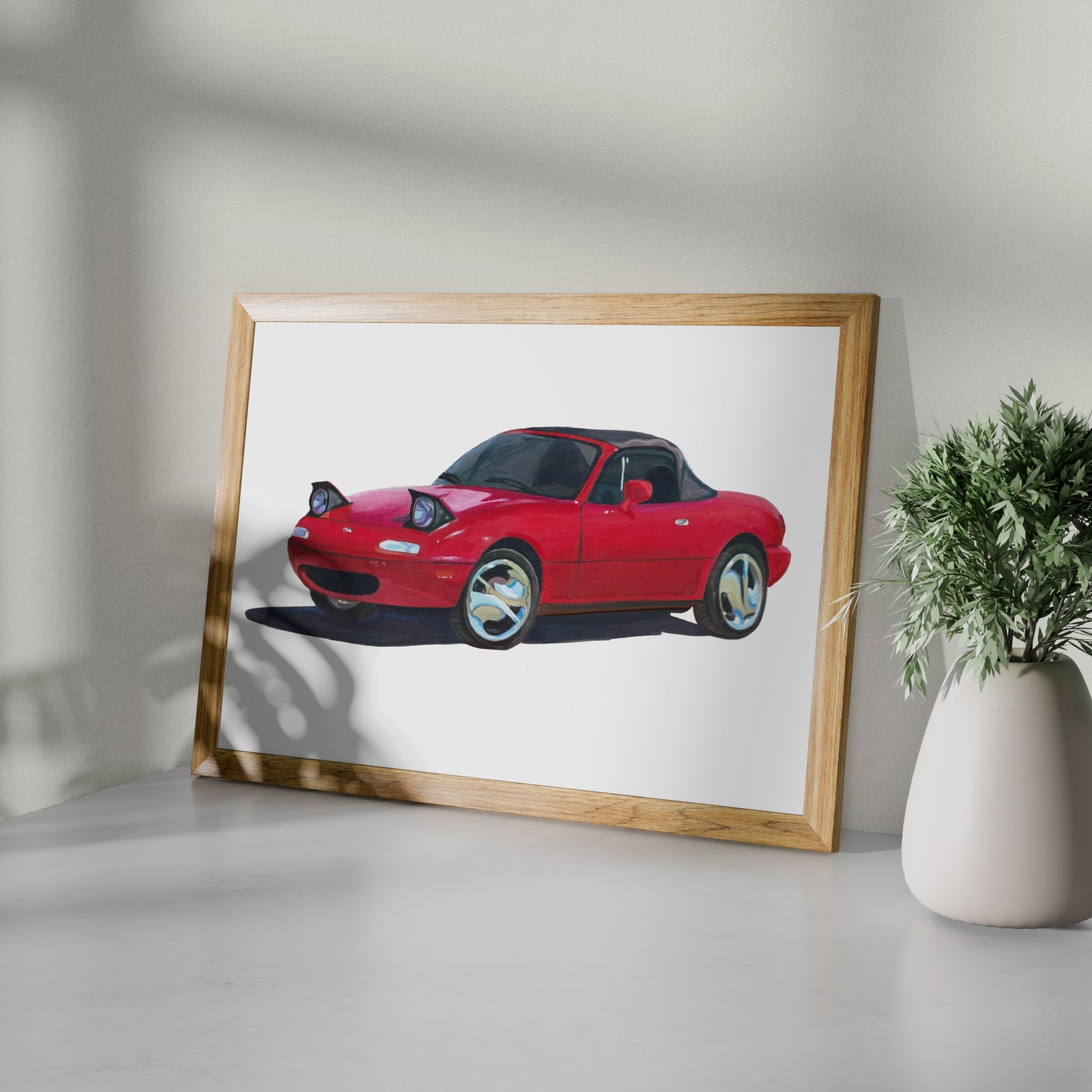 Framed red sports car art print shown at an angle on a white surface
